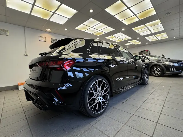Tył czarnego Audi w blasku studyjnych lamp sufitowych
