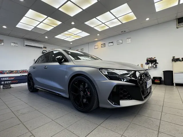 Szare Audi po profesjonalnym zabezpieczeniu lakieru zaparkowane w studio detailingowym