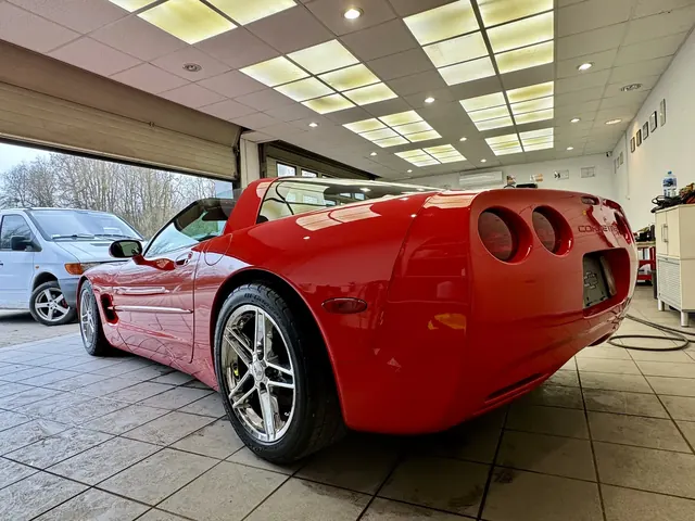 Dynamiczna linia boczna i sylwetka czerwonej Corvette w świetle lamp studyjnych