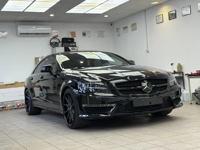 Czarnego Mercedesa CLS z widocznym grillem AMG i reflektorami LED w studio